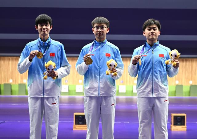 (260925) -- TOYOTA, Sept. 25, 2026 (Xinhua) -- Gold medalists Liu Yukun, Zhang Changhong, Sheng Lihao (from R to L) of team China pose for photos during the victory ceremony for the 50m rifle 3 positions men team of shooting at the 20th Asian Games Aichi-Nagoya 2026 in Toyota of Aichi Prefecture, Japan, Sept. 25, 2026. (Xinhua/Liu Lei)