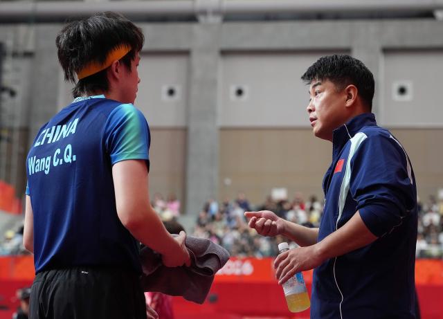 (260925) -- TOYOTA, Sept. 25, 2026 (Xinhua) -- Wang Chuqin of China listens to coach Wang Hao (R) during the table tennis men's singles round 2 match against Thitaphat Preechayan of Thailand at the 20th Asian Games Aichi-Nagoya 2026 in Toyota of Aichi Prefecture, Japan, Sept. 25, 2026. (Xinhua/Cheong Kam Ka)