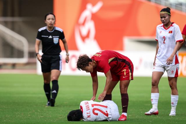 (260925) -- OSAKA, Sept. 25, 2026 (Xinhua) -- Wang Shuang (2nd R) of China checks the condition of Ngan Thi Van Su (bottom) of Vietnam during the quarterfinal match of women's football between China and Vietnam at 20th Asian Games Aichi-Nagoya 2026 in Osaka, Japan, Sept. 25, 2026. (Xinhua/Jia Haocheng)