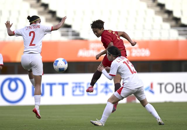(260925) -- OSAKA, Sept. 25, 2026 (Xinhua) -- Wang Shuang (C) of China heads the ball during the quarterfinal match of women's football between China and Vietnam at 20th Asian Games Aichi-Nagoya 2026 in Osaka, Japan, Sept. 25, 2026. (Xinhua/Li Ga)