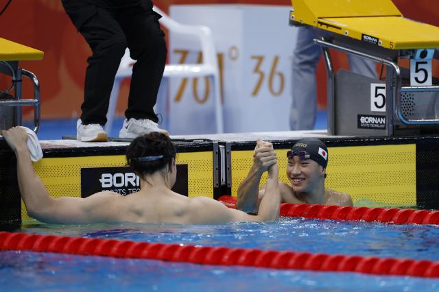 (260925) -- TOKYO, Sept. 25, 2026 (Xinhua) -- Qin Haiyang (L) of China shakes hands with Ohashi Shin of Japan after the men's 50m breaststroke final at the 20th Asian Games Aichi-Nagoya 2026 in Tokyo, Japan, Sept. 25, 2026. (Xinhua/Wu Zhizun)
