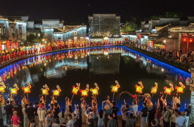 (260925) -- HEFEI, Sept. 25, 2026 (Xinhua) -- A drone photo taken on Sept. 24, 2026 shows performers parading with rabbit-shaped lanterns in Hongcun Village, Yixian County of Huangshan City, east China's Anhui Province. A lantern parade was held here in celebration of the Mid-Autumn Festival. 
   In recent years, Huangshan has been boosting its nighttime economy to unlock the local consumption potential. (Photo by Shi Yalei/Xinhua)