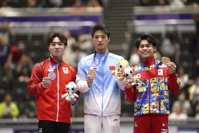 (260925) -- NAGOYA, Sept. 25, 2026 (Xinhua) -- Gold medalist Tian Hao (C) of China, silver medalist Oka Shinnosuke (L) of Japan and bronze medalist Karl Jahrel Eldrew Yulo of the Philippines pose after the awarding ceremony for the men's horizontal bar of Artistic Gymnastics at the 20th Asian Games Aichi-Nagoya 2026 in Nagoya, Japan, Sept. 25, 2026. (Xinhua/Xu Yanan)