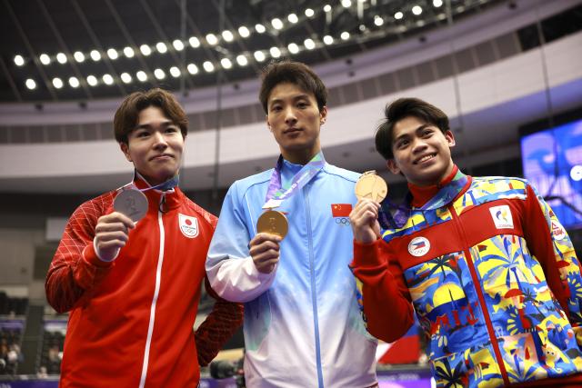 (260925) -- NAGOYA, Sept. 25, 2026 (Xinhua) -- Gold medalist Tian Hao (C) of China, silver medalist Oka Shinnosuke (L) of Japan and bronze medalist Karl Jahrel Eldrew Yulo of the Philippines pose after the awarding ceremony for the men's horizontal bar of Artistic Gymnastics at the 20th Asian Games Aichi-Nagoya 2026 in Nagoya, Japan, Sept. 25, 2026. (Xinhua/Xu Yanan)