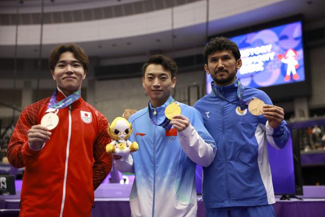 (260925) -- NAGOYA, Sept. 25, 2026 (Xinhua) -- Gold medalist Zou Jingyuan (C) of China, silver medalist Oka Shinnosuke (L) of Japan and bronze medalist Rasuljon Abdurakhimov of Uzbekistan pose during the awarding ceremony for the men's parallel bars of Artistic Gymnastics at the 20th Asian Games Aichi-Nagoya 2026 in Nagoya, Japan, Sept. 25, 2026. (Xinhua/Xu Yanan)