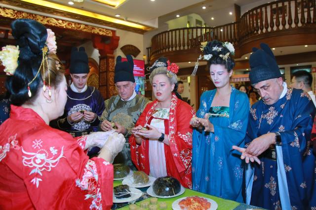 (260925) -- BEIJING, Sept. 25, 2026 (Xinhua) -- Foreign tourists dressed in Hanfu learn to make mooncakes at a restaurant in Xi'an, northwest China's Shaanxi Province, Sept. 23, 2026. TO GO WITH "China Focus: Same moon, shared stories: Foreigners find reunion in China's Mid-Autumn Festival" (Xinhua)