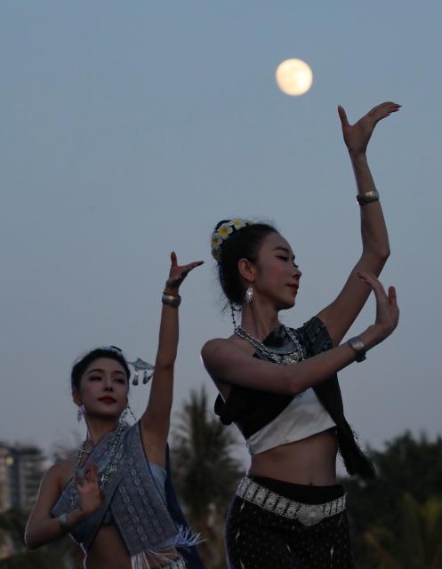 (260925) -- BEIJING, Sept. 25, 2026 (Xinhua) -- Actresses perform dance for tourists under the moonlight at a scenic area in Jinghong City, southwest China's Yunnan Province, Sept. 25, 2026. The Mid-Autumn Festival falls on Sept. 25 this year. (Photo by Li Yunsheng/Xinhua)