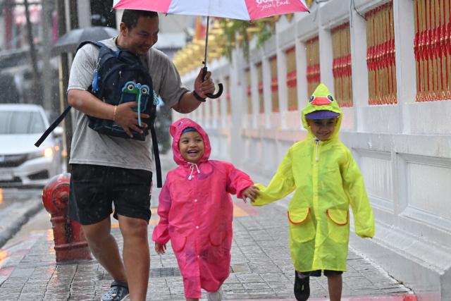 (260925) -- BANGKOK, Sept. 25, 2026 (Xinhua) -- Pedestrians walk on a street in the rain in Bangkok, Thailand, on Sept. 25, 2026. The Thai Meteorological Department has issued a warning of heavy rain in Greater Bangkok and other provinces across Thailand, due to a strong low-pressure system combined with seasonal monsoon patterns. (Xinhua/Rachen Sageamsak)