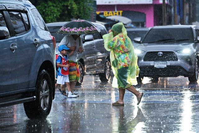 (260925) -- BANGKOK, Sept. 25, 2026 (Xinhua) -- Pedestrians cross a street in the rain in Bangkok, Thailand, on Sept. 25, 2026. The Thai Meteorological Department has issued a warning of heavy rain in Greater Bangkok and other provinces across Thailand, due to a strong low-pressure system combined with seasonal monsoon patterns. (Xinhua/Rachen Sageamsak)