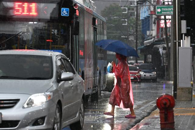 (260925) -- BANGKOK, Sept. 25, 2026 (Xinhua) -- A pedestrian crosses a street in the rain in Bangkok, Thailand, on Sept. 25, 2026. The Thai Meteorological Department has issued a warning of heavy rain in Greater Bangkok and other provinces across Thailand, due to a strong low-pressure system combined with seasonal monsoon patterns. (Xinhua/Rachen Sageamsak)