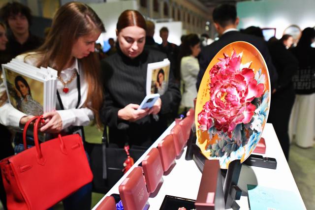 (260925) -- MOSCOW, Sept. 25, 2026 (Xinhua) -- Visitors check Chinese handcrafted porcelain works during the second Contemporary Academic Art Fair "Art Russia" in Moscow, Russia, Sept. 24, 2026. The second Contemporary Academic Art Fair "Art Russia" runs from September 24 to 27 at Moscow's Gostiny Dvor, featuring more than 100 stands dedicated to academic art. (Xinhua/Zhang Chaoqun)