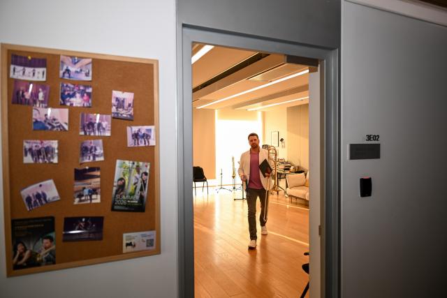(260926) -- TIANJIN, Sept. 26, 2026 (Xinhua) -- Lee Allen walks out of his studio for a rehearsal at the Tianjin Juilliard School in Tianjin, north China, Sept. 15, 2026.
  Lee Allen, a U.S. trombonist, joined the Tianjin Juilliard School as one of its first resident faculty members in 2019. 
  In 2017, while still teaching in the U.S. state of Ohio, Allen led five students on a month-long tour across China, covering 17 cities and staging 19 concerts. This immersive experience gave him deep insight into China's thriving artistic landscape. He noted that the abundance of opportunities, strong institutional support for the arts, and Tianjin's livable urban environment convinced him to build his long-term career here. 
  Over the years, Allen has dedicated himself to nurturing young musical talent, with generations of his students going on to perform on leading international stages. His two children were both born and raised in Tianjin, making the city a true family home. 
  This year, the Tianjin Juilliard School formed its first all-faculty brass quintet, a rare opportunity that allows Allen to perform alongside his peers and deepen his artistic practice. 
  For Allen, music bridges different civilizations, and the Tianjin Juilliard School is a dynamic platform for exchange between Chinese and U.S. arts education. "Teaching is a two-way journey of growth," he said. "While I guide my students, they also teach me every day." (Xinhua/Sun Fanyue)