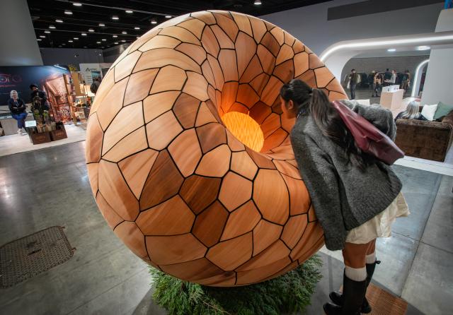 (260926) -- VANCOUVER, Sept. 26, 2026 (Xinhua) -- A visitor examines a large sculptural furniture piece during the Interior Design Show 2026 at the Vancouver Convention Centre in Vancouver, British Columbia, Canada, Sept. 25, 2026.
  Featuring 200 exhibitors from around the world showcasing the latest interior design concepts and products, the three-day trade and public show kicked off Friday and runs until Sept. 27. (Photo by Liang Sen/ Xinhua)