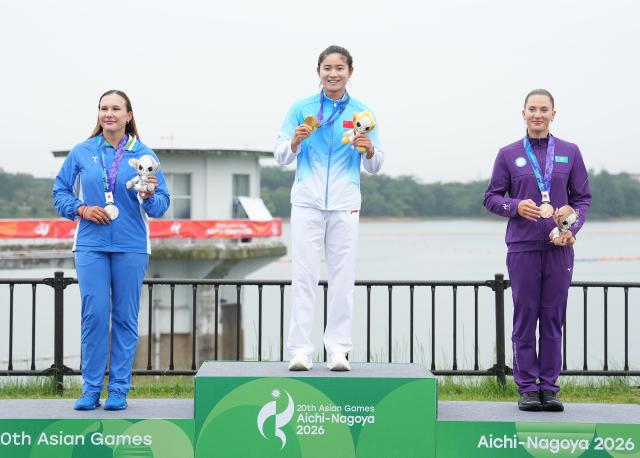 (260926) -- NAGOYA, Sept. 26, 2026 (Xinhua) -- Gold medalist Wang Nan (C) of China, silver medalist Arina Tanatmisheva (L) of Uzbekistan, bronze medalist Stella Sukhanova of Kazakhstan pose for photos during the victory ceremony for the women's kayak single 500m of canoe sprint at the 20th Asian Games Aichi-Nagoya 2026 in Miyoshi of Aichi Prefecture, Japan, Sept. 26, 2026. (Xinhua/Zhang Haobo)