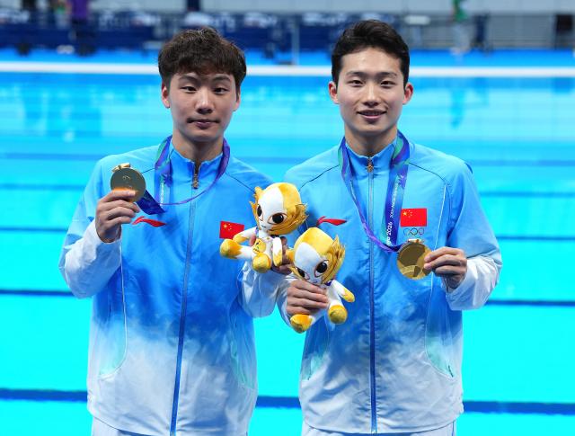 (260926) -- TOKYO, Sept. 26, 2026 (Xinhua) -- Gold medalists Wang Zongyuan (R)/Zheng Jiuyuan pose for photos after the victory ceremony for the men's synchronised 3m springboard of diving at the 20th Asian Games Aichi-Nagoya 2026 in Tokyo, Japan, Sept. 26, 2026. (Xinhua/Chen Zeguo)