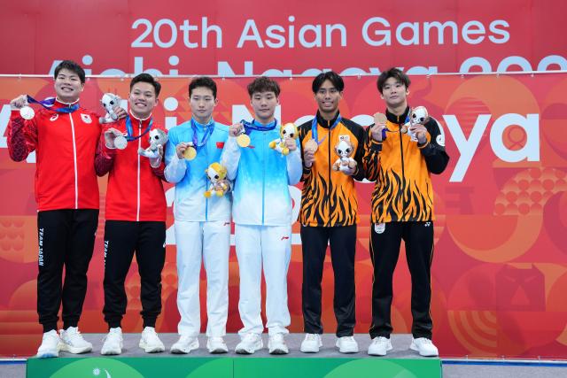 (260926) -- TOKYO, Sept. 26, 2026 (Xinhua) -- Gold medalists Wang Zongyuan (3rd L)/Zheng Jiuyuan (3rd R) of China, silver medalists Ikuma Senri (2nd L)/Suyama Haruki (1st L) of Japan and bronze medalists Yong Rui Jie (1st R)/Nurqayyum Mohamad of Malaysia pose for photos during the victory ceremony for the men's synchronised 3m springboard of diving at the 20th Asian Games Aichi-Nagoya 2026 in Tokyo, Japan, Sept. 26, 2026. (Xinhua/Chen Zeguo)