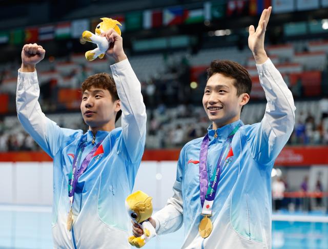 (260926) -- TOKYO, Sept. 26, 2026 (Xinhua) -- Gold medalists Wang Zongyuan (R)/Zheng Jiuyuan greet the spectators after the victory ceremony for the men's synchronised 3m springboard of diving at the 20th Asian Games Aichi-Nagoya 2026 in Tokyo, Japan, Sept. 26, 2026. (Xinhua/Wu Zhizun)