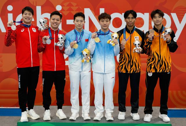 (260926) -- TOKYO, Sept. 26, 2026 (Xinhua) -- Gold medalists Wang Zongyuan (3rd L)/Zheng Jiuyuan (3rd R) of China, silver medalists Ikuma Senri (2nd L)/Suyama Haruki (1st L) of Japan and bronze medalists Yong Rui Jie (1st R)/Nurqayyum Mohamad of Malaysia pose for photos during the victory ceremony for the men's synchronised 3m springboard of diving at the 20th Asian Games Aichi-Nagoya 2026 in Tokyo, Japan, Sept. 26, 2026. (Xinhua/Wu Zhizun)