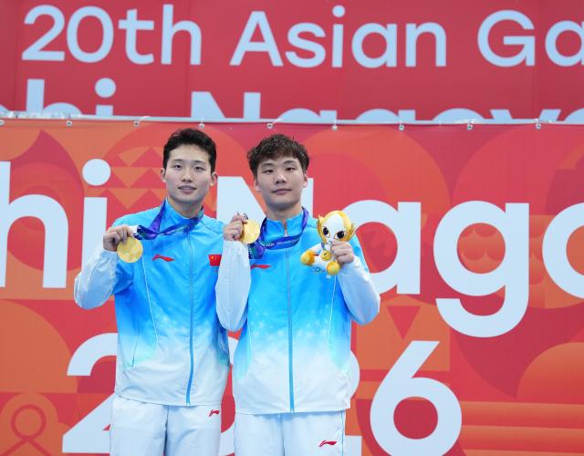 (260926) -- TOKYO, Sept. 26, 2026 (Xinhua) -- Gold medalists Wang Zongyuan (L)/Zheng Jiuyuan pose for photos during the victory ceremony for the men's synchronised 3m springboard of diving at the 20th Asian Games Aichi-Nagoya 2026 in Tokyo, Japan, Sept. 26, 2026. (Xinhua/Chen Zeguo)