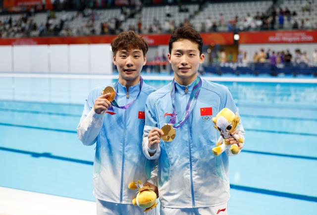 (260926) -- TOKYO, Sept. 26, 2026 (Xinhua) -- Gold medalists Wang Zongyuan (R)/Zheng Jiuyuan pose for photos after the victory ceremony for the men's synchronised 3m springboard of diving at the 20th Asian Games Aichi-Nagoya 2026 in Tokyo, Japan, Sept. 26, 2026. (Xinhua/Wu Zhizun)