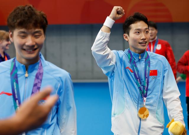 (260926) -- TOKYO, Sept. 26, 2026 (Xinhua) -- Gold medalists Wang Zongyuan (R)/Zheng Jiuyuan react after the victory ceremony for the men's synchronised 3m springboard of diving at the 20th Asian Games Aichi-Nagoya 2026 in Tokyo, Japan, Sept. 26, 2026. (Xinhua/Wu Zhizun)