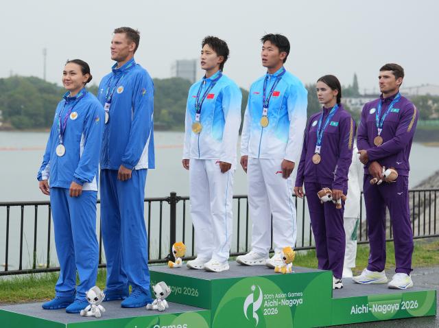 (260926) -- NAGOYA, Sept. 26, 2026 (Xinhua) -- Gold medalists Wu Shengyue (3rd R)/Ma Yanan (3rd L) of China, silver medalists Vladlen Denisov (2nd L)/Nilufar Zokirova (1st L) of Uzbekistan, bronze medalists Sergey Yemelyanov (1st R)/Rufina Iskakova of Kazakhstan react during the victory ceremony for the mixed canoe double 500m of canoe sprint at the 20th Asian Games Aichi-Nagoya 2026 in Miyoshi of Aichi Prefecture, Japan, Sept. 26, 2026. (Xinhua/Zhang Haobo)