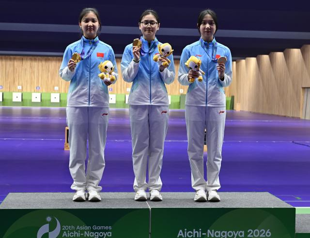 (260926) -- NAGOYA, Sept. 26, 2026 (Xinhua) -- Gold medalists Zhang Liyuan (L), Han Jiayu (C) and Wang Zifei of team China pose during the victory ceremony for the 50m rifle 3 positions women team of shooting at the 20th Asian Games Aichi-Nagoya 2026 in Toyota of Aichi Prefecture, Japan, Sept. 26, 2026. (Xinhua/Liu Lei)