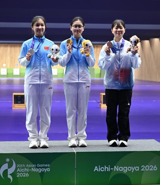 (260926) -- TOYOTA, Sept. 26, 2026 (Xinhua) -- Gold medalist Han Jiayu (C) of China, silver medalist Zhang Liyuan (L) of China and bronze medalist Kim Jieun of South Korea pose during the victory ceremony for the 50m rifle 3 positions women individual of shooting at the 20th Asian Games Aichi-Nagoya 2026 in Toyota of Aichi Prefecture, Japan, Sept. 26, 2026. (Xinhua/Liu Lei)