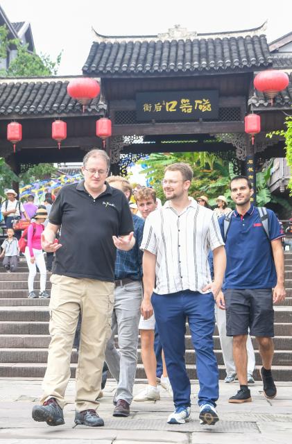 (260927) -- CHONGQING, Sept. 27, 2026 (Xinhua) -- Francis Stonier (1st L) and his colleagues visit the Ciqikou ancient town in southwest China's Chongqing Municipality, Sept. 19, 2026.
  Since arriving in Chongqing in 2019 to take up a teaching post, U.S. scholar Francis Stonier has become a well-known local figure. Over the past few years, he has devoted himself to promoting STEAM (Science, Technology, Engineering, Arts, Mathematics) interdisciplinary education and free science outreach for rural school students.
  Currently a professor at Southwest University, Stonier teaches academic writing to international students. Beyond his university lectures, Stonier brings science to life for primary and secondary school students. He simplifies complex concepts, tailoring them for young children. 
  To make science more accessible, Stonier has developed personalized STEAM curricula. Using 3D printing and LEGO bricks, he transforms complex academic concepts into hands-on experiments, encouraging students to explore science through creation and teamwork. In a creative lesson at Bashu Primary School in Chongqing, Stonier used everyday items to simulate birds' foraging behaviors, helping kids understand natural science through play. 
  Since 2019, Stonier has visited nearly 80 primary and secondary schools across Chongqing, including those in remote rural areas, to give free science lessons. 
  Stonier's grassroots teaching experience has also reshaped his understanding of education. He speaks highly of Chinese educators' openness to practical and innovative teaching approaches. 
  Stonier has witnessed Chongqing's development. He has fully immersed himself in local life. Moved by the warmth of the Chongqing people, and the city's unique charm and diverse cuisine, Stonier regards Chongqing as his second hometown, praising its harmonious balance of urban convenience and natural scenery. (Xinhua/Tang Yi)