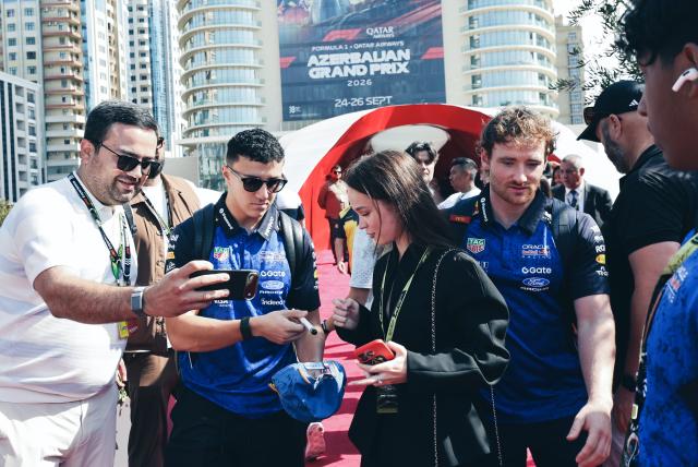 (260927) -- BAKU, Sept. 27, 2026 (Xinhua) -- Red Bull Racing's Isack Hadjar of France (2nd L, front) interacts with fans ahead of the Formula One Azerbaijan Grand Prix at the Baku City Circuit in Baku, on Sept. 26, 2026. (Xinhua/Chen Junfeng)