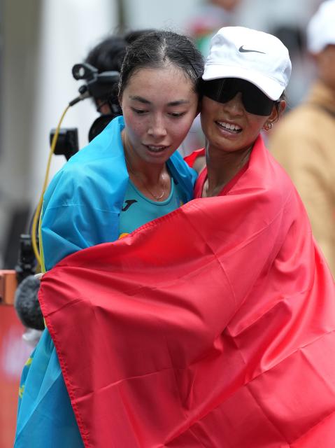 (260927) -- NAGOYA, Sept. 27, 2026 (Xinhua) -- Danzengquzong (R) of China and Yasmina Toxanbayeva of Kazakhstan hug after the women's marathon race walk final of Athletics at the 20th Asian Games Aichi-Nagoya 2026 in Nagoya, Japan, Sept. 27, 2026. (Xinhua/Luo Yuan)