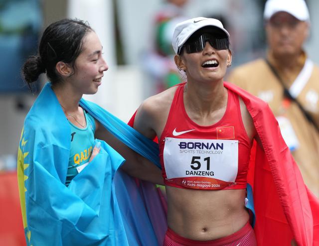 (260927) -- NAGOYA, Sept. 27, 2026 (Xinhua) -- Danzengquzong (R) of China and Yasmina Toxanbayeva of Kazakhstan interact after the women's marathon race walk final of Athletics at the 20th Asian Games Aichi-Nagoya 2026 in Nagoya, Japan, Sept. 27, 2026. (Xinhua/Luo Yuan)