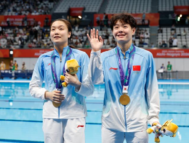 (260927) -- TOKYO, Sept. 27, 2026 (Xinhua) -- Gold medalists Chen Yiwen (R)/Chen Jia of China react after the victory ceremony for the women's synchronised 3m springboard of diving at the 20th Asian Games Aichi-Nagoya 2026 in Tokyo, Japan, Sept. 27, 2026. (Xinhua/Wu Zhizun)