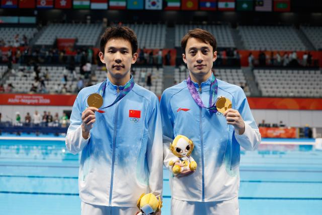 (260927) -- TOKYO, Sept. 27, 2026 (Xinhua) -- Gold medalists Yang Hao (L)/Lian Junjie of China pose for photos after the victory ceremony for the men's synchronised 10m platform of diving at the 20th Asian Games Aichi-Nagoya 2026 in Tokyo, Japan, Sept. 27, 2026. (Xinhua/Wu Zhizun)