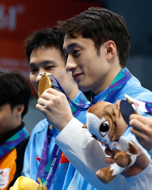 (260927) -- TOKYO, Sept. 27, 2026 (Xinhua) -- Gold medalists Yang Hao/Lian Junjie (R) of China pose for photos during the victory ceremony for the men's synchronised 10m platform of diving at the 20th Asian Games Aichi-Nagoya 2026 in Tokyo, Japan, Sept. 27, 2026. (Xinhua/Wu Zhizun)