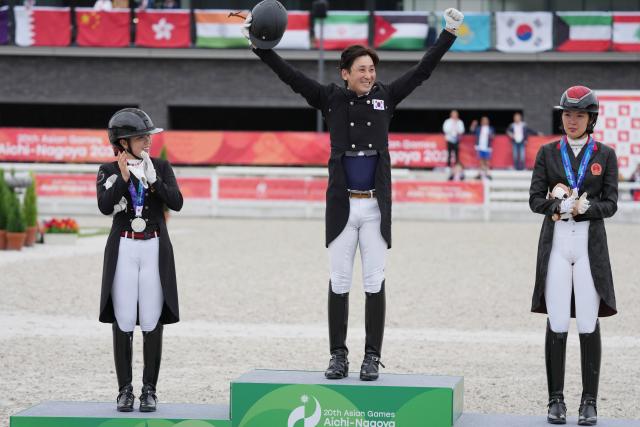 (260927) -- TOKYO, Sept. 27, 2026 (Xinhua) -- Gold medalist Nam Dongheon (C) of South Korea celebrates during the victory ceremony for the dressage individual of equestrian at the 20th Asian Games Aichi-Nagoya 2026 in Tokyo, Japan, Sept. 27, 2026. (Photo by Wang Shen/Xinhua)