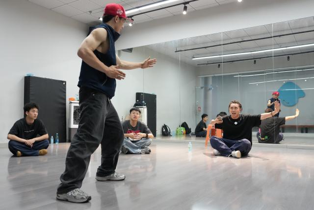 (260927) -- CHENGDU, Sept. 27, 2026 (Xinhua) -- Fang Zhenghua (1st R) discusses with team members at Dancehome studio in Chengdu, southwest China's Sichuan Province, June 13, 2026.
  Fang Zhenghua, a post-90s choreographer, has participated in the production of a series of eye-catching dancing performances, including a show featuring dancers and humanoid robots at the opening ceremony of the 48th WorldSkills Competition. For Fang, street dance has never been merely a passing trend.
   Fang's love for street dance began at the age of 13, when he first learned popular dance moves from television. That early fascination soon grew into a lifelong pursuit, driving him to explore new possibilities on stage. A big fan of Chinese martial arts novels since childhood, Fang has integrated Sichuan Opera face-changing techniques, traditional Kung Fu movements and other distinct Chinese cultural elements into his choreography.
   In March 2025, Fang and Homies, a street dance team of his studio Dancehome, won third place at the VIBE Dance Competition with their work "Sword and Qi in Sichuan." This was the first time a Chinese team had claimed an award in the competition's 30-year history. His team has also collaborated with domestic humanoid robot developers, staging performances that showcase China's technological advances. 
   Nearly 20 years of dedication has brought Fang to stages around the world. "When we compete abroad, our goal is not just to show the world how Chinese dancers move," he said. "We want them to see a rich, diverse China through every step we take." (Xinhua/Xu Bingjie)