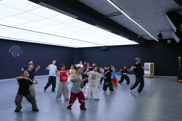 (260927) -- CHENGDU, Sept. 27, 2026 (Xinhua) -- Children take a class at Dancehome studio in Chengdu, southwest China's Sichuan Province, June 13, 2026.
  Fang Zhenghua, a post-90s choreographer, has participated in the production of a series of eye-catching dancing performances, including a show featuring dancers and humanoid robots at the opening ceremony of the 48th WorldSkills Competition. For Fang, street dance has never been merely a passing trend.
   Fang's love for street dance began at the age of 13, when he first learned popular dance moves from television. That early fascination soon grew into a lifelong pursuit, driving him to explore new possibilities on stage. A big fan of Chinese martial arts novels since childhood, Fang has integrated Sichuan Opera face-changing techniques, traditional Kung Fu movements and other distinct Chinese cultural elements into his choreography.
   In March 2025, Fang and Homies, a street dance team of his studio Dancehome, won third place at the VIBE Dance Competition with their work "Sword and Qi in Sichuan." This was the first time a Chinese team had claimed an award in the competition's 30-year history. His team has also collaborated with domestic humanoid robot developers, staging performances that showcase China's technological advances. 
   Nearly 20 years of dedication has brought Fang to stages around the world. "When we compete abroad, our goal is not just to show the world how Chinese dancers move," he said. "We want them to see a rich, diverse China through every step we take." (Xinhua/Xu Bingjie)
