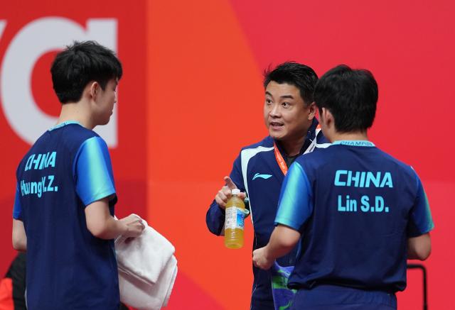 (260927) -- TOYOTA, Sept. 27, 2026 (Xinhua) -- Lin Shidong (R)/Huang Youzheng of China listen to coach Wang Hao (C) during the men's doubles final table tennis match between Lin Shidong/Huang Youzheng of China and Harimoto Tomokazu/Shinozuka Hiroto of Japan at the 20th Asian Games Aichi-Nagoya 2026 in Toyota of Aichi Prefecture, Japan, Sept. 27, 2026. (Xinhua/Cheong Kam Ka)