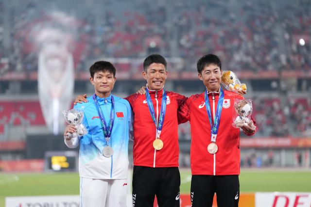 (260927) -- NAGOYA, Sept. 27, 2026 (Xinhua) -- Gold medalist Katsuki Hayato (C) of Japan, silver medalist Zhou Yingcheng (L) of China and bronze medalist Suwa Motofumi of Japan pose during the awarding ceremony for the men's marathon race walk final of Athletics at the 20th Asian Games Aichi-Nagoya 2026 in Nagoya, Japan, Sept. 27, 2026. (Xinhua/Jia Yuchen)