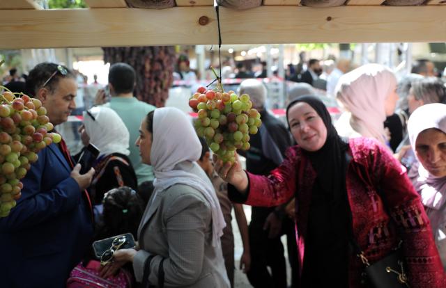 (260927) -- HEBRON, Sept. 27, 2026 (Xinhua) -- Palestinians attend an annual grapes festival in the West Bank city of Hebron, Sept. 26, 2026. (Photo by Mamoun Wazwaz/Xinhua)