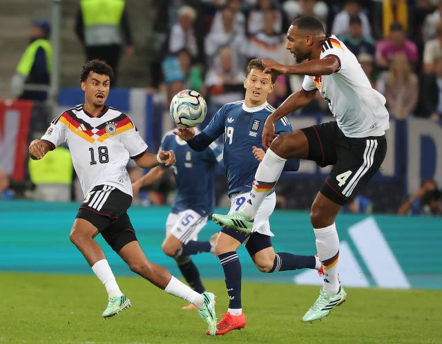 (260928) -- AUGSBURG, Sept. 28, 2026 (Xinhua) -- Jonathan Tah (R), Nathaniel Brown (L) of Germany vie with Konstantinos Karetsas of Greece during the UEFA Nations League 2026/27 League A Group A match between Germany and Greece in Augsburg, Germany, Sept. 27, 2026. (Photo by Philippe Ruiz/Xinhua)
