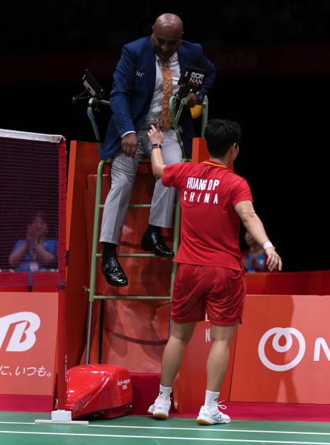 (260928) -- ICHINOMIYA, Sept. 28, 2026 (Xinhua) -- Huang Dongping (bottom) of China gestures as she talks with an umpire after the mixed doubles semifinals of badminton between Feng Yanzhe/Huang Dongping of China and Amri Syahnawi/Nita Violina Marwah of Indonesia at the 20th Asian Games Aichi-Nagoya 2026 in Ichinomiya of Aichi Prefecture, Japan, Sept. 28, 2026. (Xinhua/Li Bo)