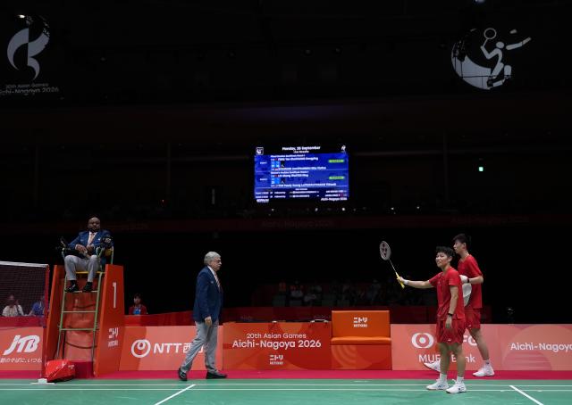 (260928) -- ICHINOMIYA, Sept. 28, 2026 (Xinhua) -- Feng Yanzhe (1st R)/Huang Dongping (2nd R) of China communicate with an umpire during the mixed doubles semifinals of badminton against Amri Syahnawi/Nita Violina Marwah of Indonesia at the 20th Asian Games Aichi-Nagoya 2026 in Ichinomiya of Aichi Prefecture, Japan, Sept. 28, 2026. (Xinhua/Li Bo)