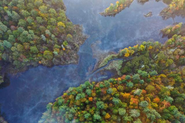 (260928) -- HARBIN, Sept. 28, 2026 (Xinhua) -- An aerial drone photo taken on Sept. 27, 2026 shows the scenery of Jingpo Lake scenic area in Mudanjiang City, northeast China's Heilongjiang Province. In autumn, Heilongjiang Province is filled with vibrant colors. Mountains, forests and waters form a picturesque landscape, showcasing the beauty of autumn in northeastern China. (Photo by Wang Zhe/Xinhua)