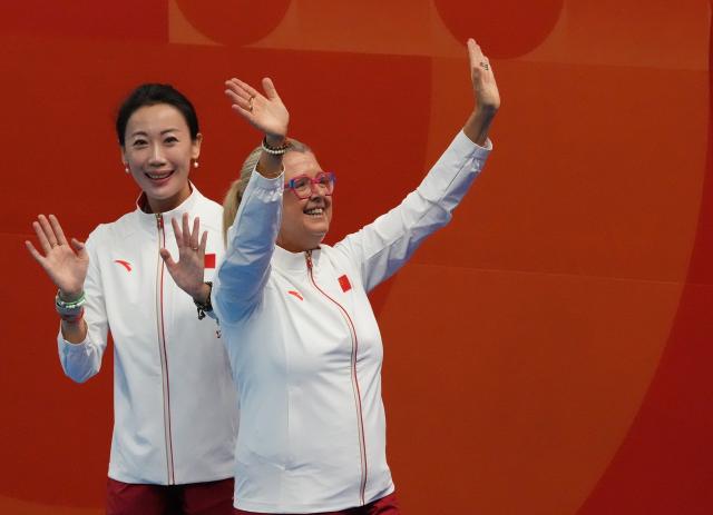 (260928) -- SHIZUOKA, Sept. 28, 2026 (Xinhua) -- China's coach Zhang Xiaohuan and Ana Tarres (R) greet spectators after the mixed team free routine of artistic swimming at the 20th Asian Games Aichi-Nagoya 2026 in Shizuoka, Japan, Sept. 28, 2026. (Xinhua/Zhou Mi)