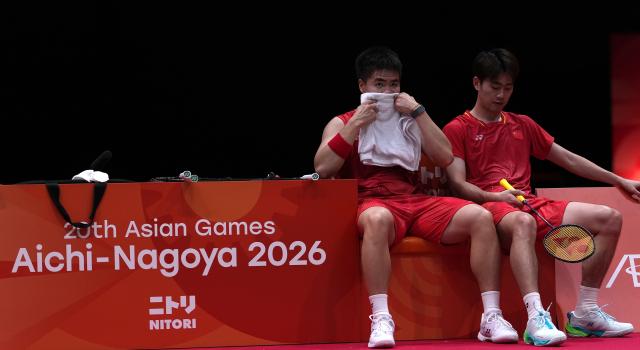 (260928) -- ICHINOMIYA, Sept. 28, 2026 (Xinhua) -- Liang Weikeng (L)/Wang Chang of China react during the men's doubles semifinals of badminton against Fajar Alfian/Muhammad Shohibul Fikri of Indonesia at the 20th Asian Games Aichi-Nagoya 2026 in Ichinomiya of Aichi Prefecture, Japan, Sept. 28, 2026. (Xinhua/Li Bo)