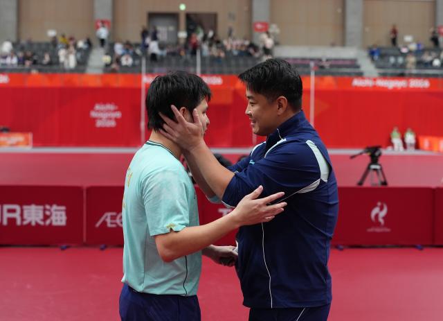 (260928) -- TOYOTA, Sept. 28, 2026 (Xinhua) -- Lin Shidong (L) and coach Wang Hao of China interact after the men's singles semifinals of table tennis against Lin Yun-ju of Chinese Taipei at the 20th Asian Games Aichi-Nagoya 2026 in Toyota of Aichi Prefecture, Japan, Sept. 28, 2026. (Xinhua/Cheong Kam Ka)