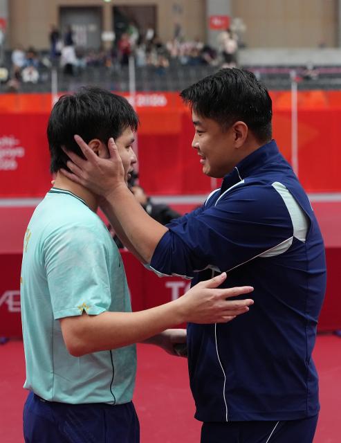 (260928) -- TOYOTA, Sept. 28, 2026 (Xinhua) -- Lin Shidong (L) and coach Wang Hao of China interact after the men's singles semifinals of table tennis against Lin Yun-ju of Chinese Taipei at the 20th Asian Games Aichi-Nagoya 2026 in Toyota of Aichi Prefecture, Japan, Sept. 28, 2026. (Xinhua/Cheong Kam Ka)