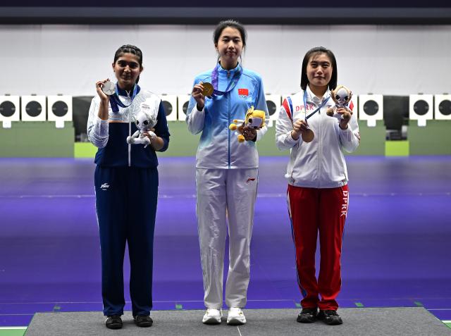 (260928) -- TOYOTA, Sept. 28, 2026 (Xinhua) -- Gold medalist Xiao Jiaruixuan (C) of China, silver medalist Esha Singh (L) of India, bronze medalist Kim Hyon Suk of the Democratic People's Republic of Korea (DPRK) pose for photos during the victory ceremony for the 25m pistol women individual of shooting at the 20th Asian Games Aichi-Nagoya 2026 in Toyota of Aichi Prefecture, Japan, Sept. 28, 2026. (Xinhua/Liu Lei)